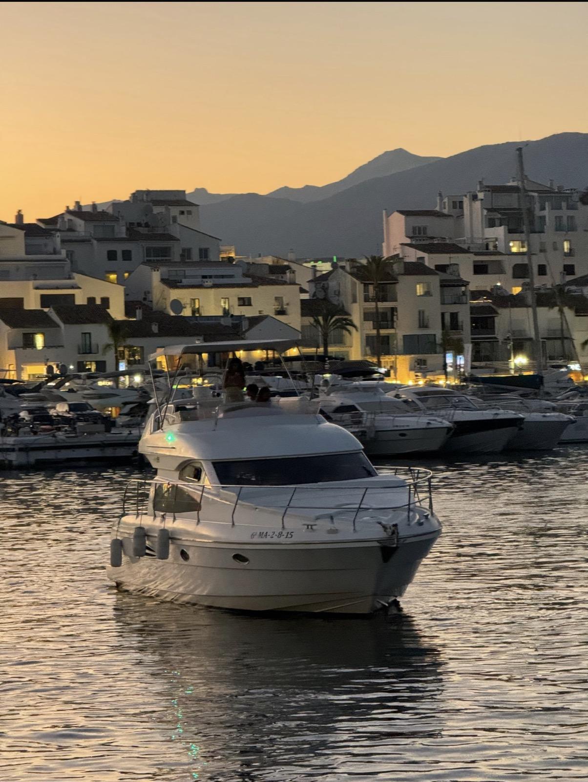 Charter yacht arriving Puerto Banús marina at sunset