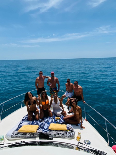 Mixed group of eight guests on the bow of our motor yacht — Marbella charter