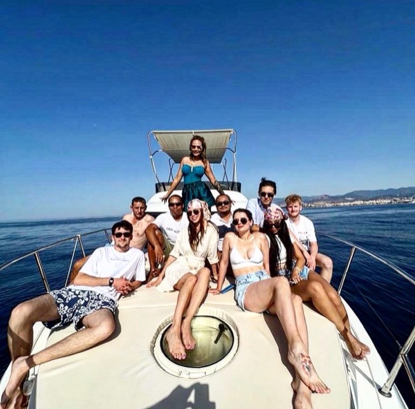 Group of guests on the bow with the Sierra Blanca mountains behind — Marbella